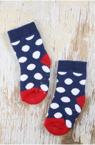 Navy cotton baby socks with white polka dots and dark red soles.
