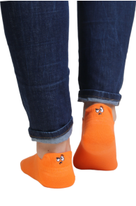 Orange low-cut cotton socks with a face, worn with dark blue jeans.