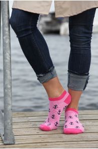 Pink socks with an anchor pattern, visibly mid-calf length on the legs.