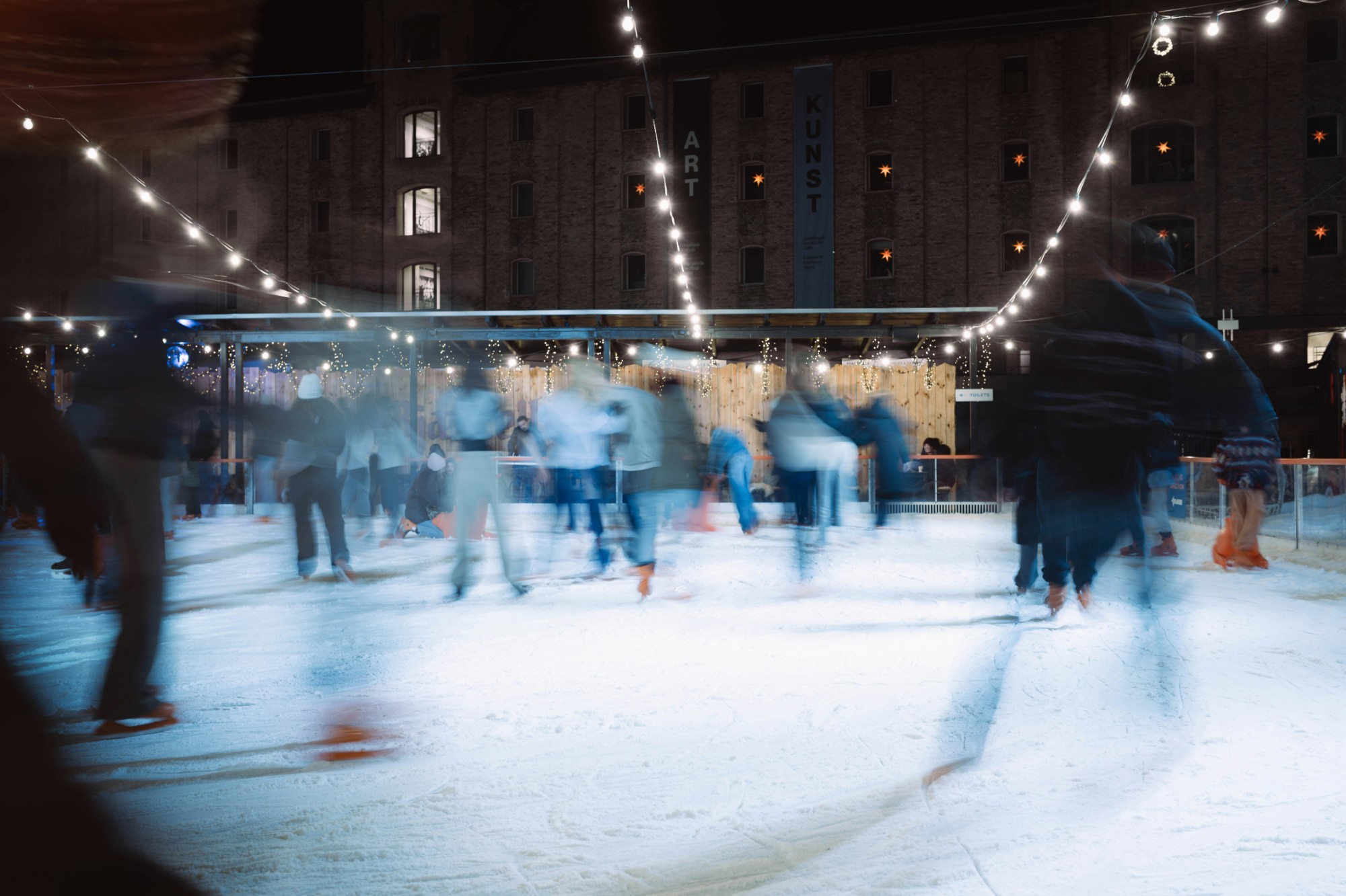 Uisutajad õhtusel liuväljal tulede all